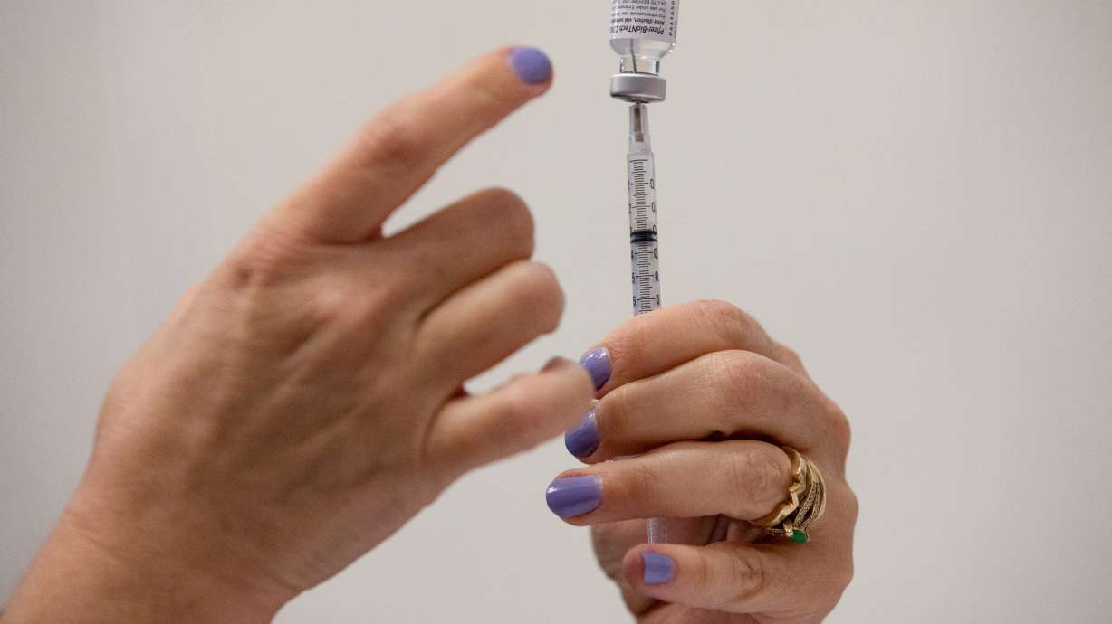 A nurse fills up syringes for patients as they receive their coronavirus disease booster vaccination during a Pfizer-BioNTech vaccination clinic in Southfield, Michigan, Sept. 29.