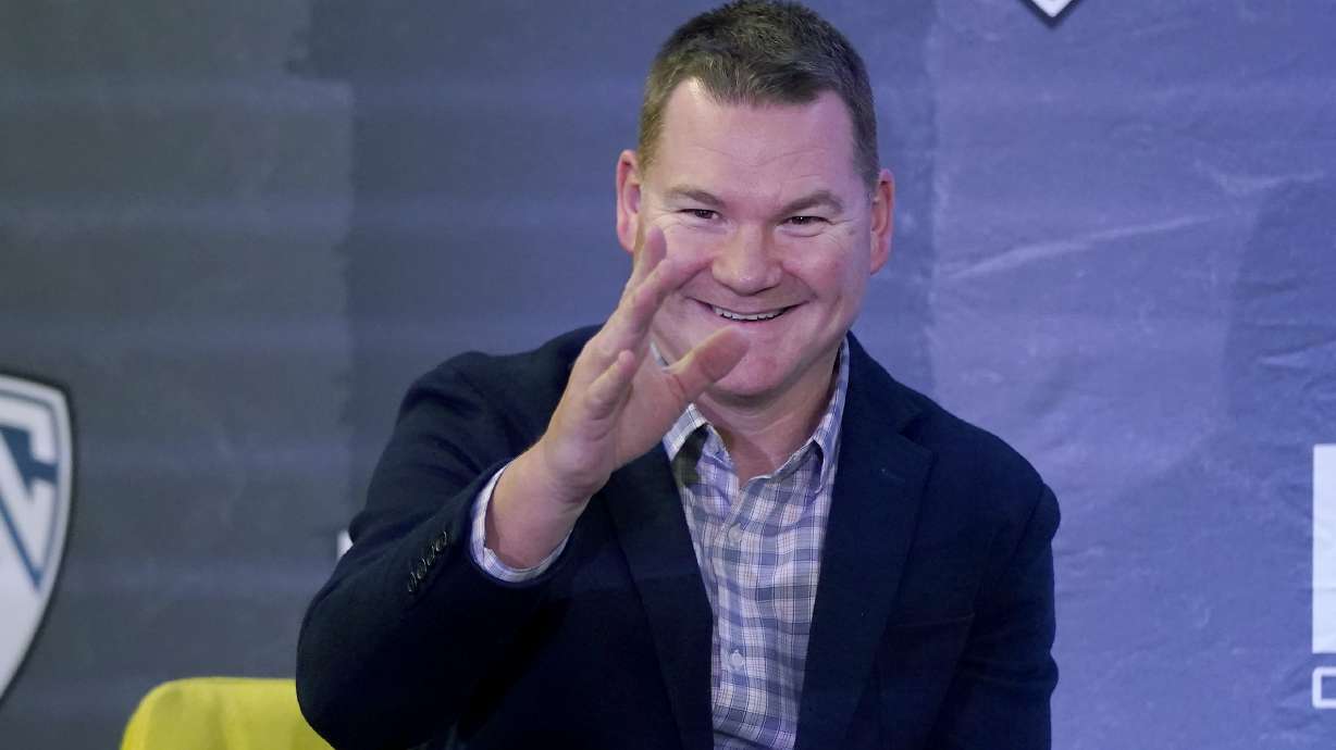 Arizona coach Tommy Lloyd waves while speaking during the Pac-12 Conference men's NCAA college basketball media day in San Francisco.