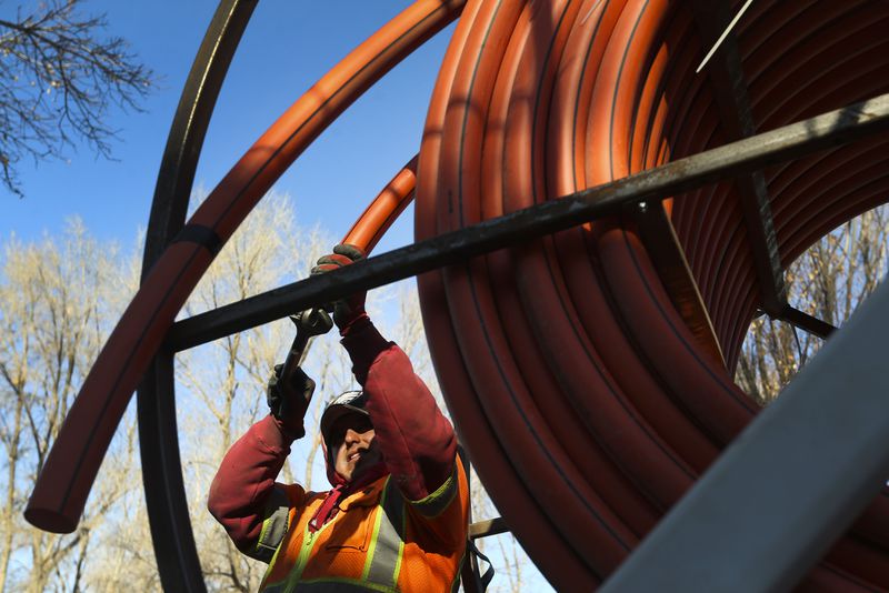 Jose Reyes, of LightLink Communications, uncoils cable
to be installed for broadband internet in Salt Lake City on Dec. 3,
2020.