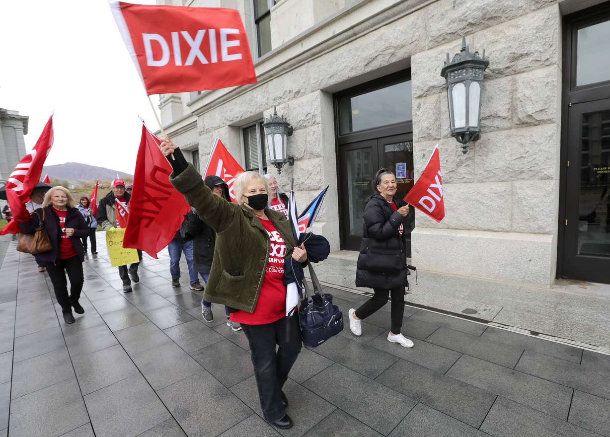 Dixie State alumni Velaine Turnbull waves a Dixie flag during a rally in support of keeping the name Dixie State University outside of the Capitol in Salt Lake City on Tuesday.