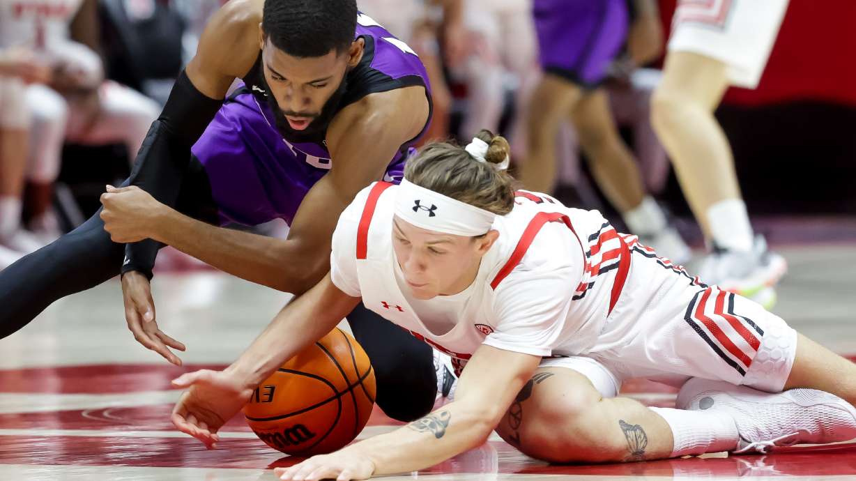 Abilene Christian Wildcats guard Reggie Miller (10) and Utah Utes guard Gabe Madsen (55) scramble for a loose ball at the Huntsman Center in Salt Lake City on Tuesday, Nov. 9, 2021.