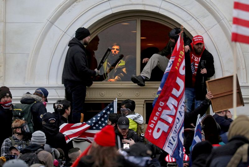 A mob storm the U.S. Capitol Building in Washington, Jan. 6. A man filmed punching a police officer during the deadly attack received a 41-month prison sentence on Wednesday.