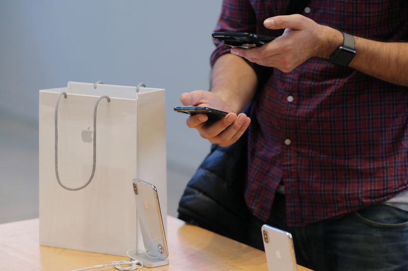 A man uses his older iPhone to photograph his new iPhone X at an Apple store in New York on Nov. 3, 2017.