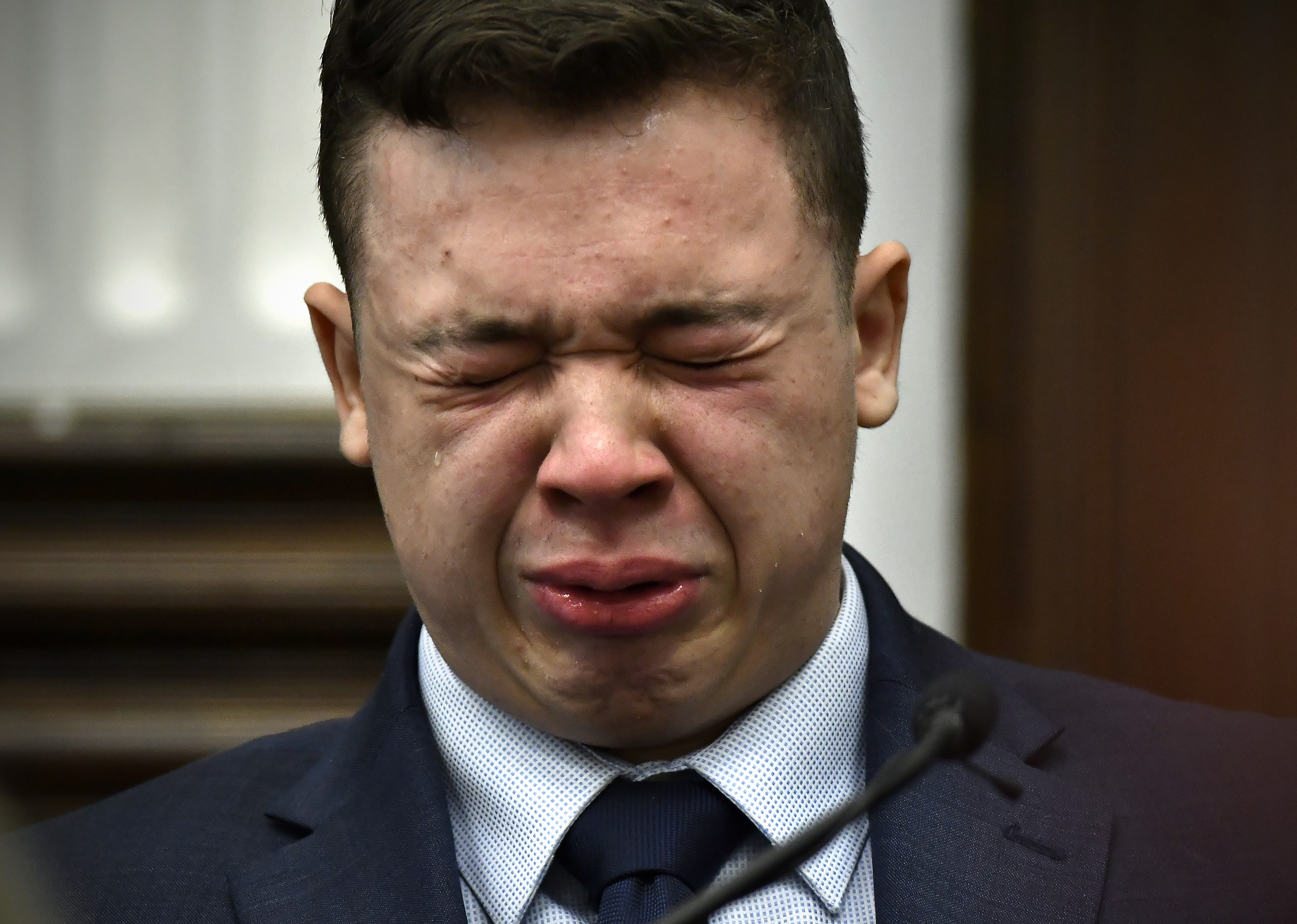 Kyle Rittenhouse breaks down on the stand as he testifies about his encounter with the late Joseph Rosenbaum during his trial at the Kenosha County Courthouse in Kenosha, Wis., on Wednesday. Rittenhouse is accused of killing two people and wounding a third during a protest over police brutality in Kenosha, last year.