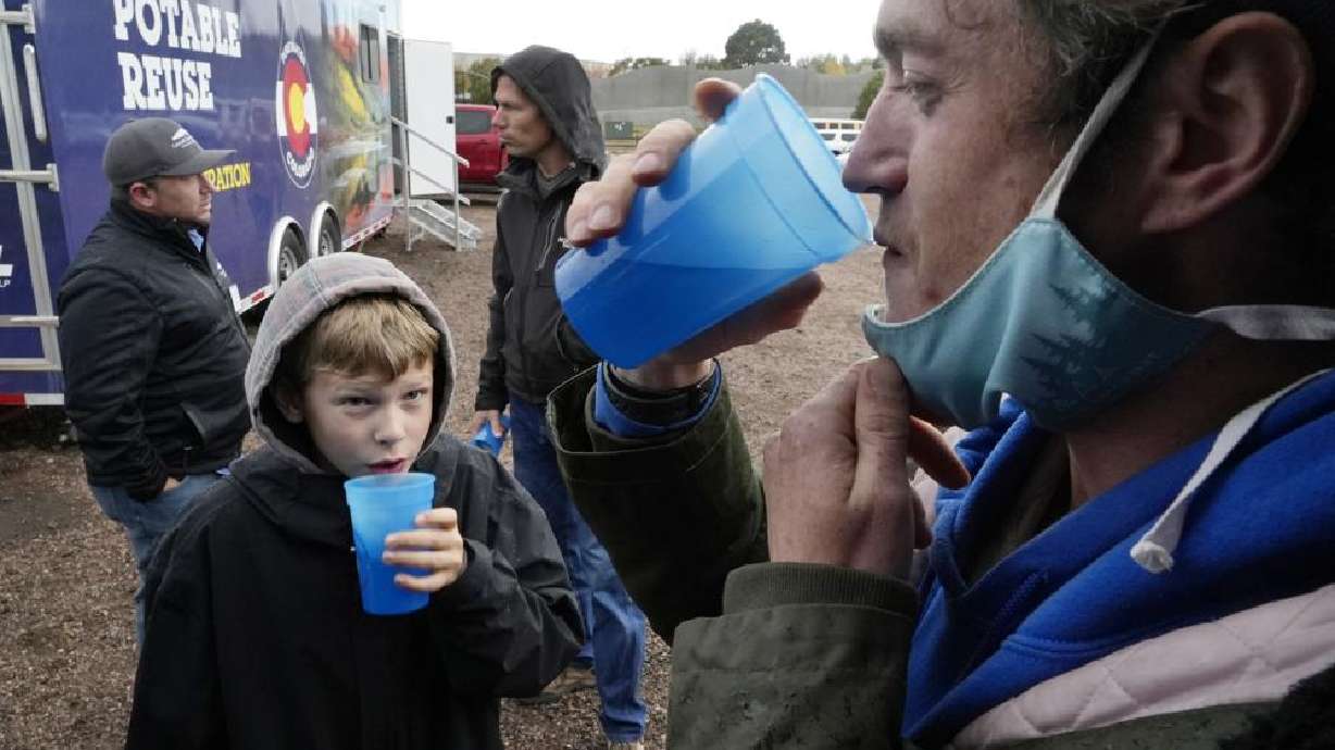 Connor Sonnenberg, foreground left, and Billy Kinn, foreground right, drink wastewater that was sterilized at the PureWater Colorado Mobile Demonstration using a method that involves carbon-based purification, Thursday, Oct. 14, 2021, in Colorado Springs, Colo. Across the U.S., cities are increasingly embracing the idea of sterilizing wastewater from toilets, sinks and factories, and piping it back into homes and businesses for drinking.