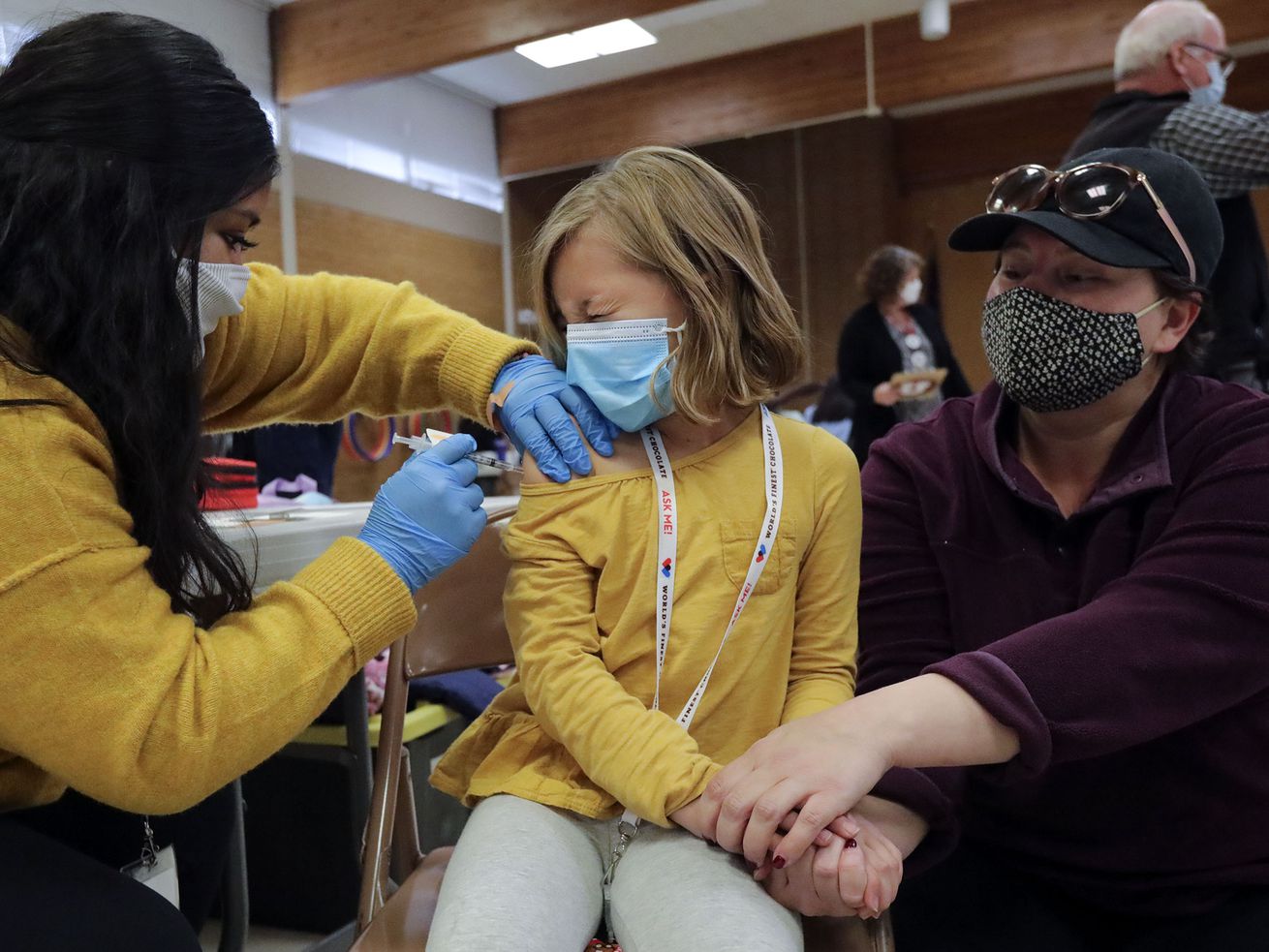 Claudia Ceron, a Salt Lake County Health Department
community health worker and vaccinator, gives Etta Bastian, 7, a
COVID-19 vaccination as Etta’s mother, Courtney Bastian, holds her
hand at Hillsdale Elementary School in West Valley City on
Nov. 8.