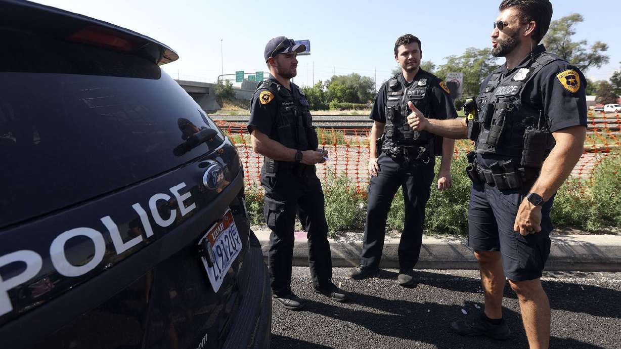 Salt Lake police officer-in-training Brenton Christian,
left, Salt Lake police officer Christopher Berry and Salt Lake
police officer Luke Johnson talk while responding to a trespassing
call in Salt Lake City on Aug. 3. The pay raise that Salt
Lake City police officers received in July appears to be helping
with retention, Mayor Erin Mendenhall and Chief Mike Brown said on
Thursday.