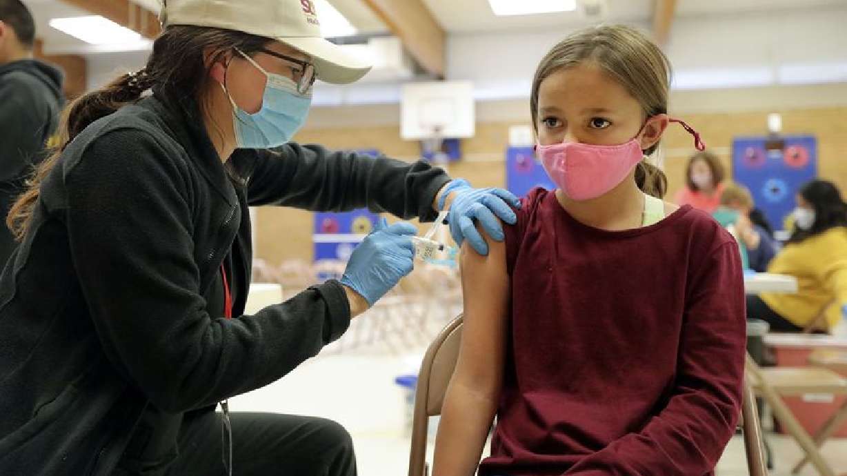 Josephine Snow, a Salt Lake County Health Department community health worker and temporary vaccinator, gives Abbie
Whipple, 10, a COVID-19 vaccination at Hillsdale Elementary School in West Valley City on Nov. 8. Utah health officials confirmed 4,502 new COVID-19 cases and 26 deaths since Friday.