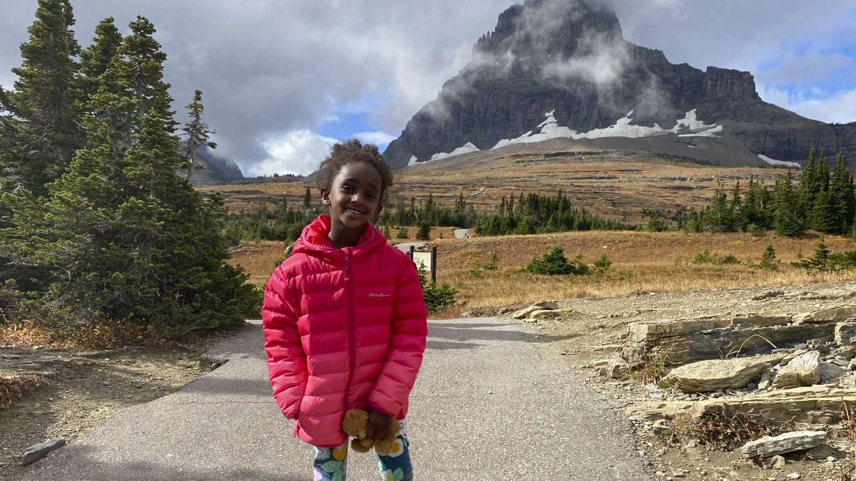In this photo provided by Ben Pascal, five-year-old Naomi Pascal, holding her teddy bear, is pictured on a hike to Hidden Lake in Glacier National Park, Mont., in October 2020. Naomi lost the bear while on the hike, but it was found by a park ranger who took care of the bear until it was spotted on the dash of his ranger truck and returned to Naomi this fall.