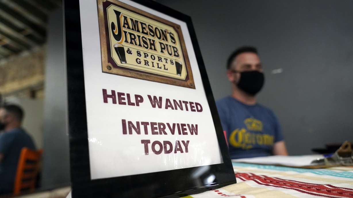 A hiring sign is placed at a booth for Jameson's Irish Pub during a job fair Wednesday, Sept. 22, in the West Hollywood section of Los Angeles. Americans quit their jobs at a record pace for the second straight month in September, while businesses and other employers continued to post a near-record number of available jobs.