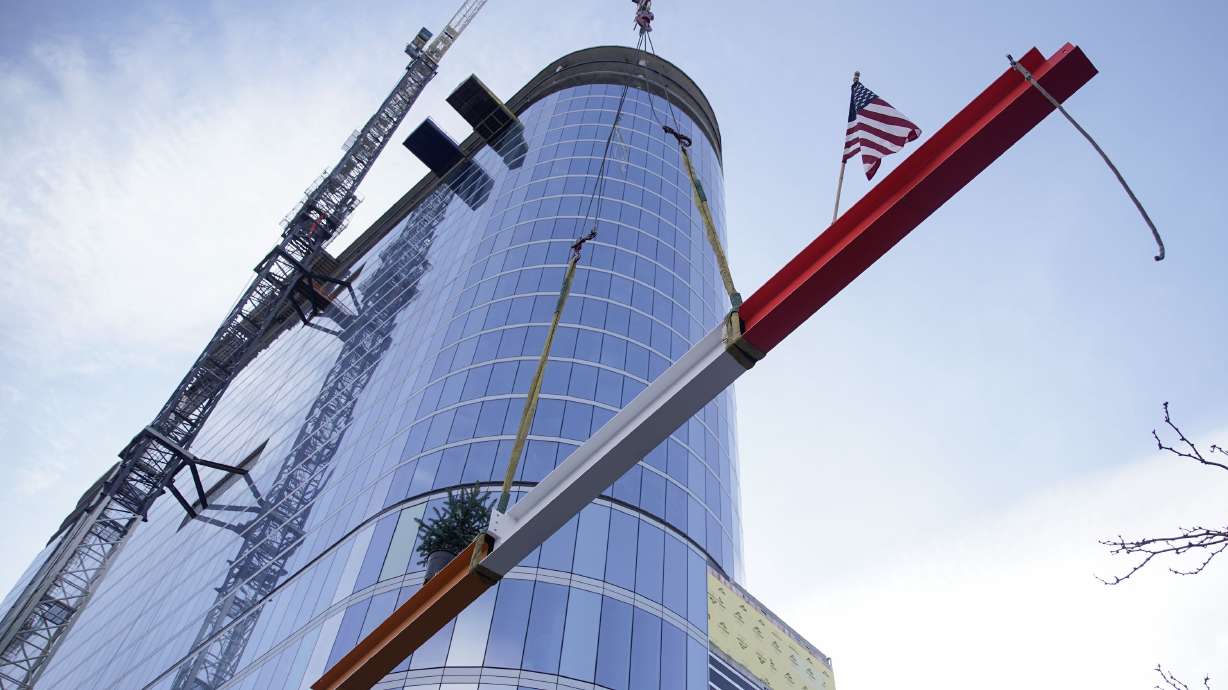 A crane lifts the final beam into place on the $377 million Hyatt Regency Salt Lake City on Friday, Nov. 12, 2021. The hotel is attached to the Salt Palace Convention Center.