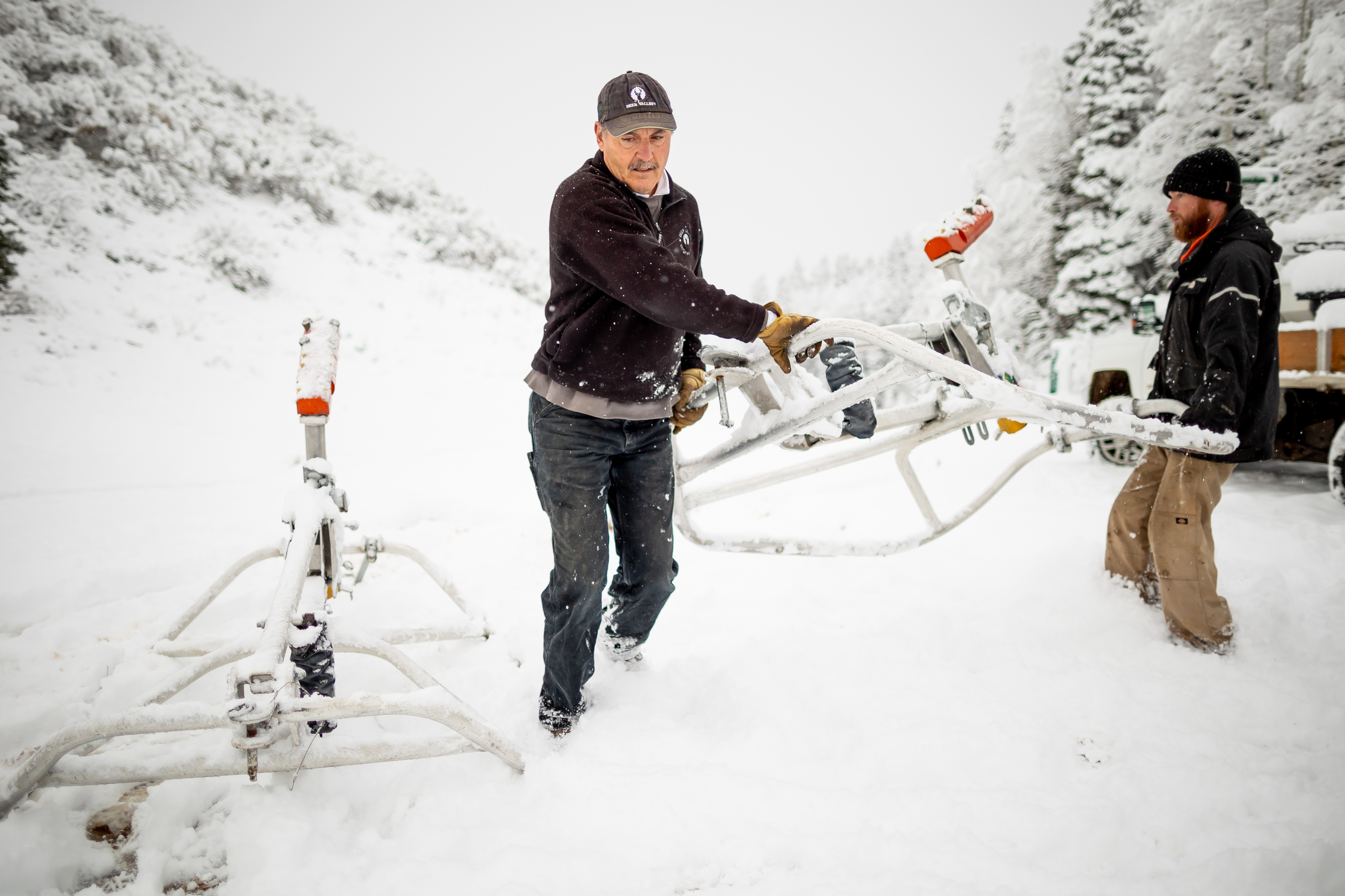Scott Enos, snowmaking manager at Deer Valley, left, and Chris Greger, a snowmaking foreman, right, unload a trailer of snow guns to be placed on a ski run at the resort in Park City on Oct. 19.