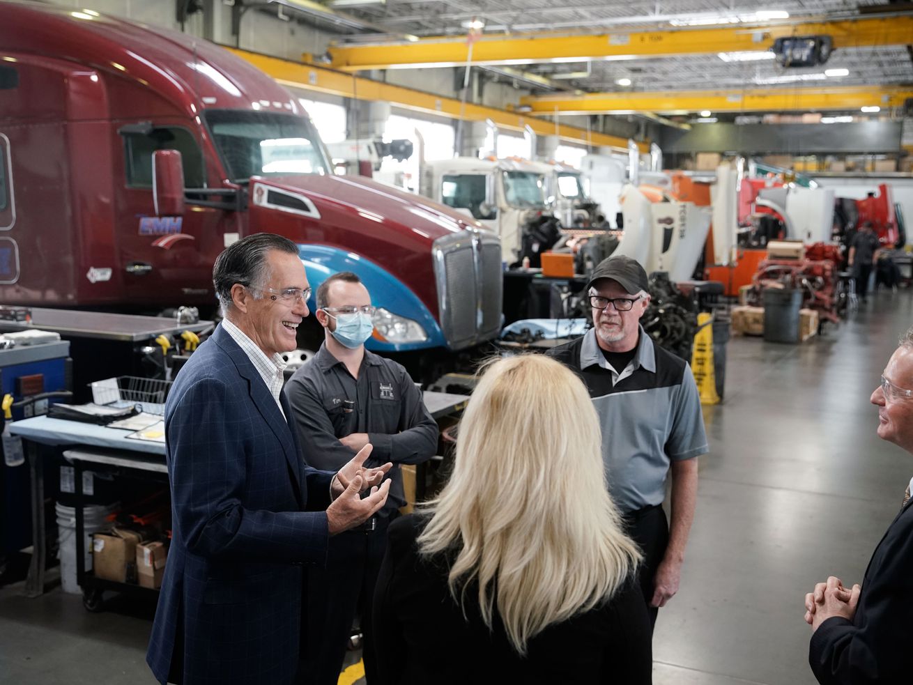Sen. Mitt Romney, R-Utah, left, laughs while talking to
Kenworth Sales executives during a tour of the company in West
Valley City on Friday. During the tour, Romney
talked about supply chain issues.