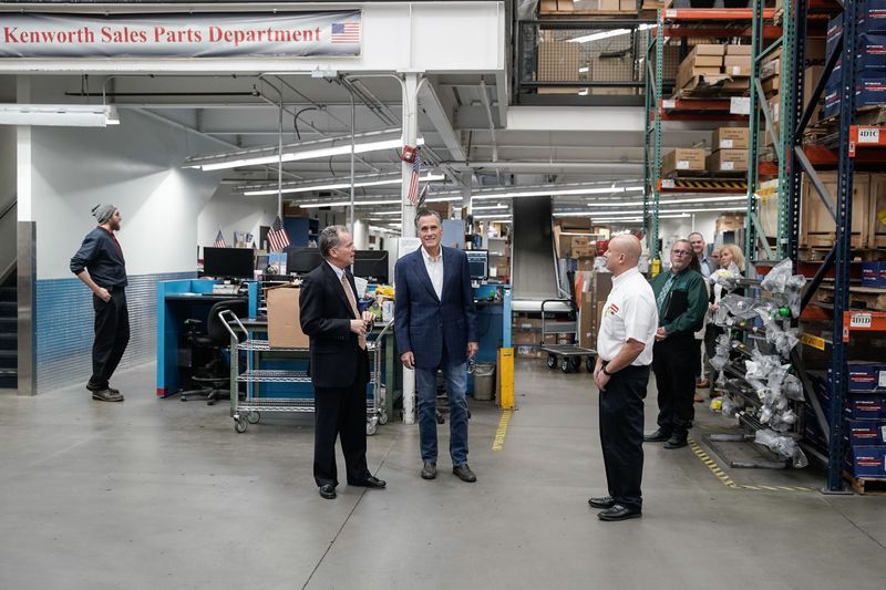 Kenworth Sales executive Kyle Treadway, left, talks
with Sen. Mitt Romney, R-Utah, during a tour of the company in West
Valley City on Friday. During the tour, Romney
talked about supply chain issues.
