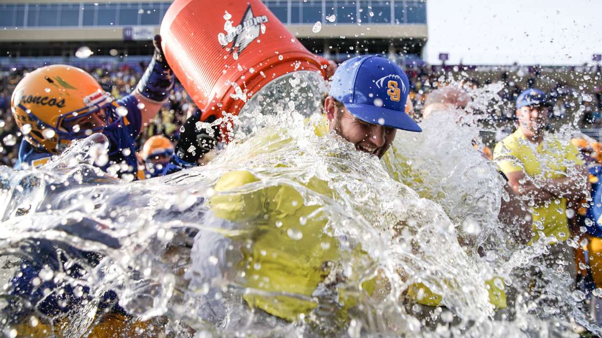 San Juan’s Dylan Black dumps water on head coach Barkley Christensen after their win against Beaver in the 2A football championship game on Saturday, Nov. 13, 2021 at Stewart Stadium in Ogden.