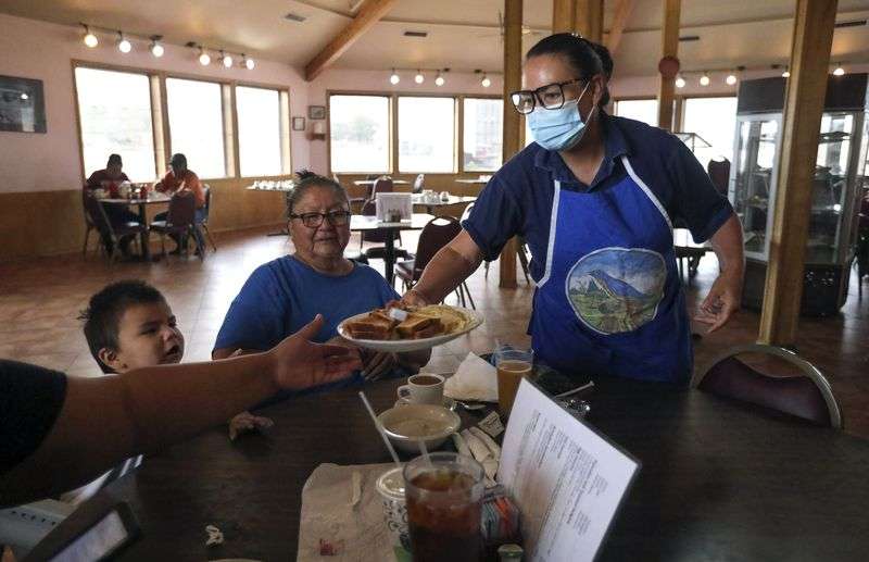 Jo Ward serves breakfast at her restaurant, the Blue Coffee Pot Restaurant, in Kayenta, Ariz., on the Navajo Nation on Thursday, Sept. 30, 2021. The restaurant is operating at half capacity after being closed for months due to COVID-19.