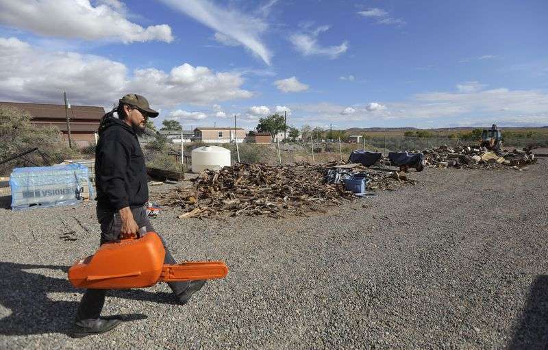Pete Sands, Utah Navajo Health System communications director and former Utah Navajo COVID-19 Relief program project manager, carries a chainsaw to cut wood behind a Utah Navajo Health System building in Montezuma Creek, San Juan County, on Friday, Oct. 1, 2021. The wood will be delivered to an Navajo elder.