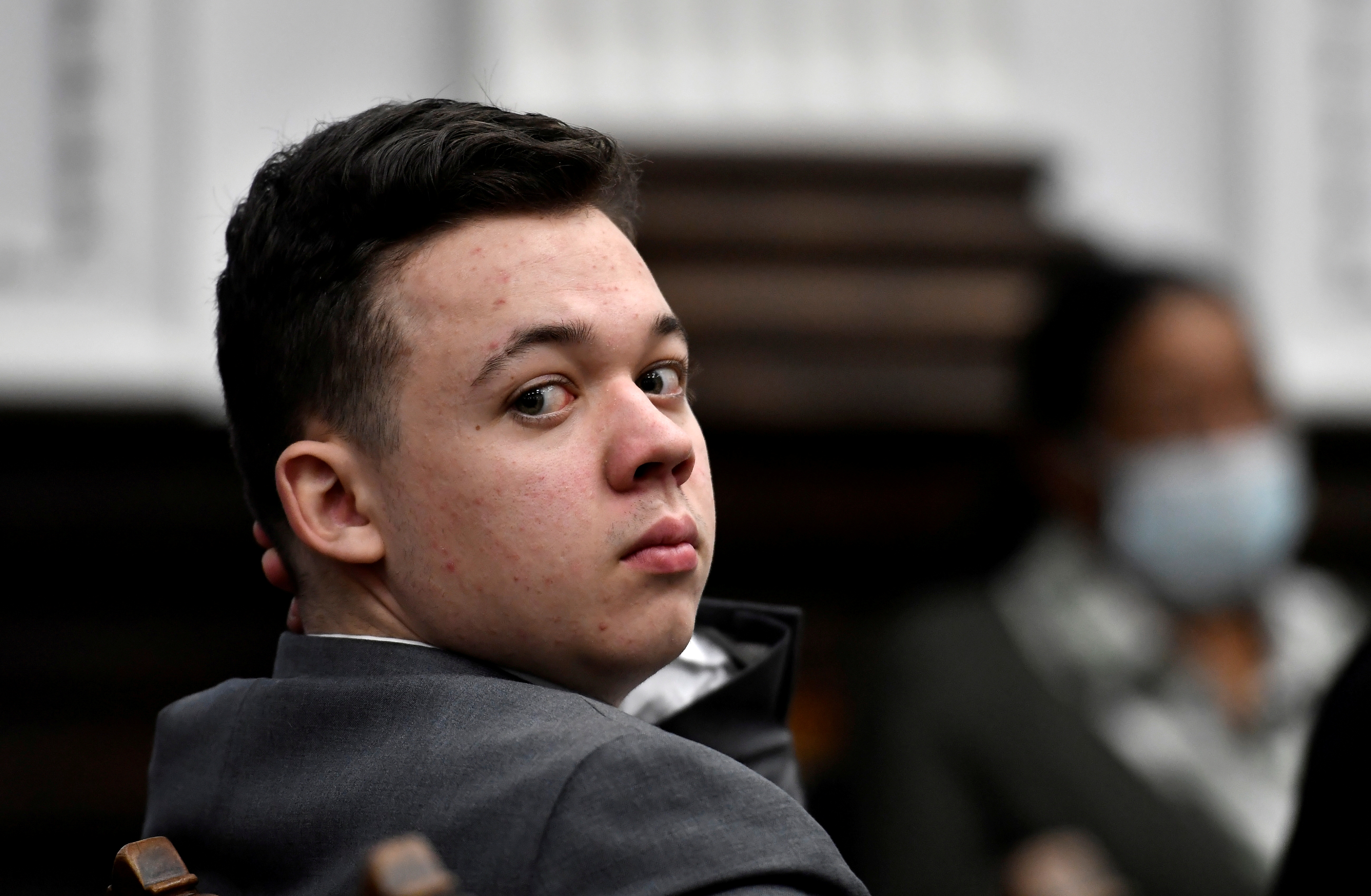 Kyle Rittenhouse looks back as attorneys argue about the charges that will be presented to the jury during proceedings at the Kenosha County Courthouse in Kenosha, Wisconsin, on Friday.
