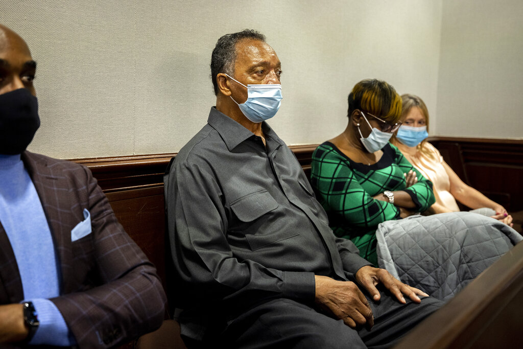 The Rev. Jesse Jackson, center, sits with Ahmaud Arbery's mother, Wanda Cooper-Jones, center right, during the trial of Greg McMichael and his son, Travis McMichael, and a neighbor, William "Roddie" Bryan in the Glynn County Courthouse on Monday, in Brunswick, Ga. The three are charged with the February 2020 slaying of 25-year-old Ahmaud Arbery.
