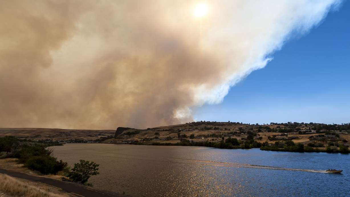A boat heads down the Snake River as smoke from the
Asotin Complex Fire west of Clarkston, Washington, wafts eastward into
Lewiston, Idaho, on July 7. The sunny skies and pleasant fall
afternoons may bode well for your mental health, but they’re not
going to help you when it comes to next year’s irrigation season.