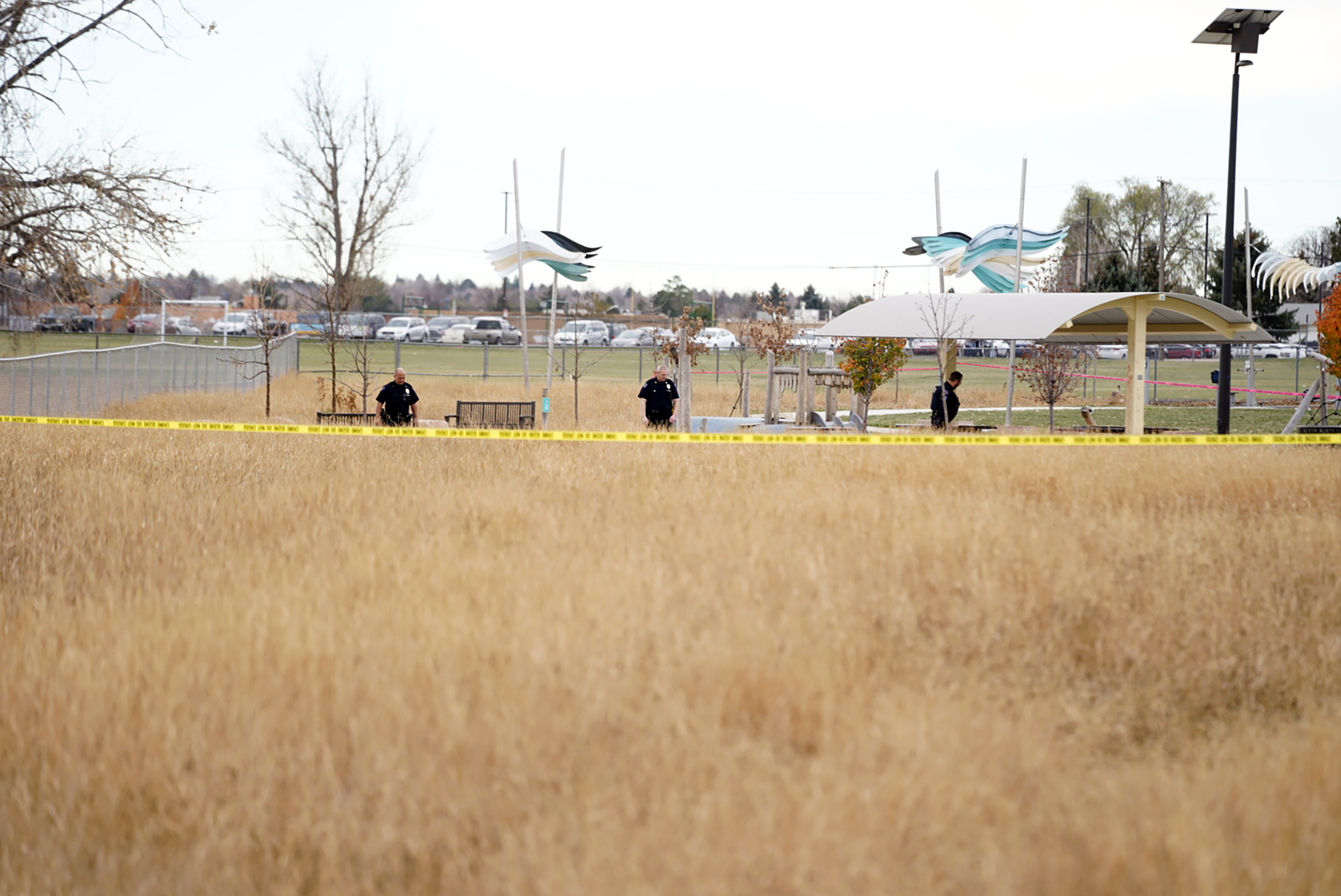 Law enforcement officers survey the scene of a shooting in which six teenagers were injured Monday in Aurora, Colo.