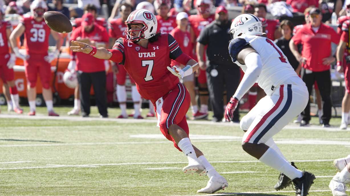Utah quarterback Cameron Rising (7) runs the option while being pressured by Arizona defensive lineman Jalen Harris in the first half of an NCAA college football game, Saturday, Nov. 13, 2021, in Tucson, Ariz.