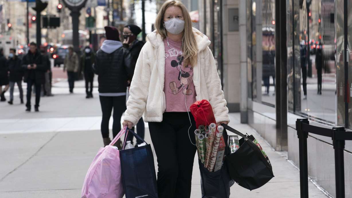 A woman carries shopping bags in New York on Dec. 10, 2020. The National Retail Federation expects that holiday sales gain could shatter last year’s record-breaking season even as a snarled global supply chain slows the flow of goods and results in higher prices for broad range of items.