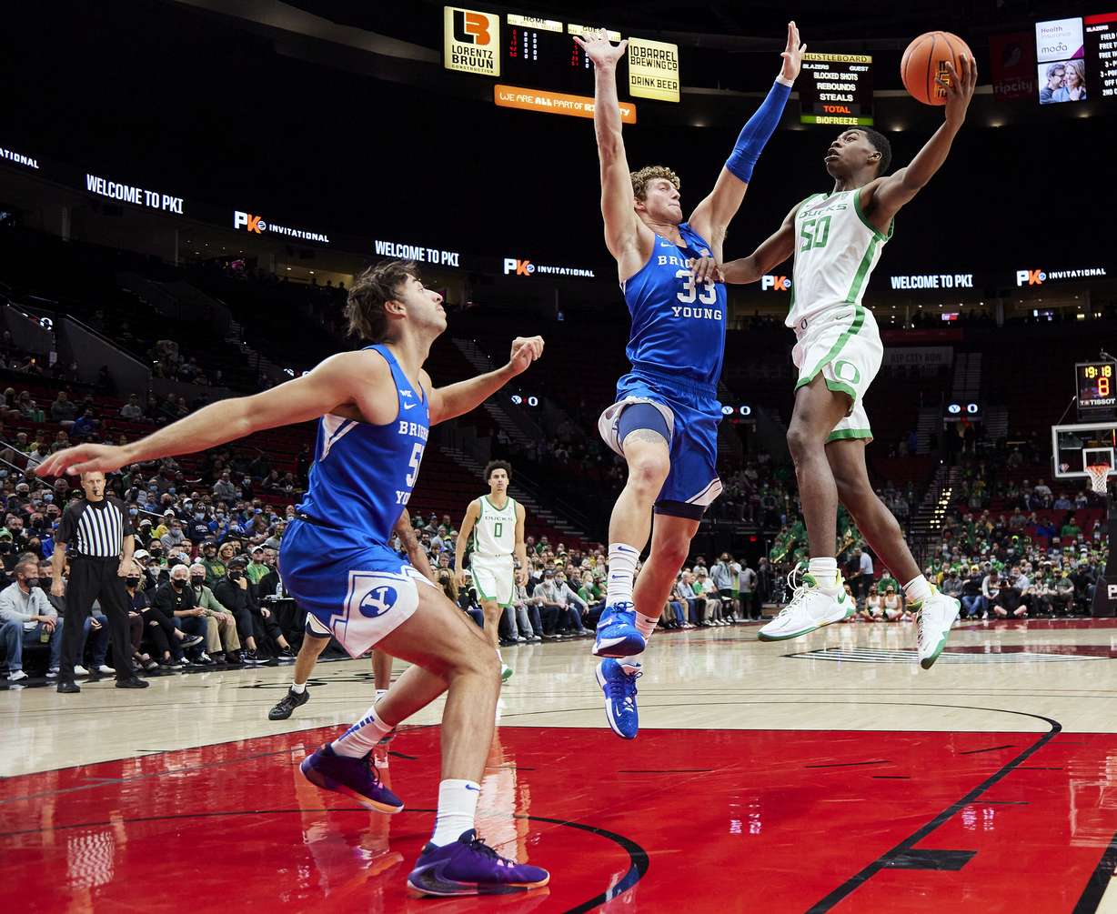 Oregon forward Eric Williams Jr., right, shoots over BYU forward Caleb Lohner, during the first half of an NCAA college basketball game in Portland, Ore., Tuesday, Nov. 16, 2021.