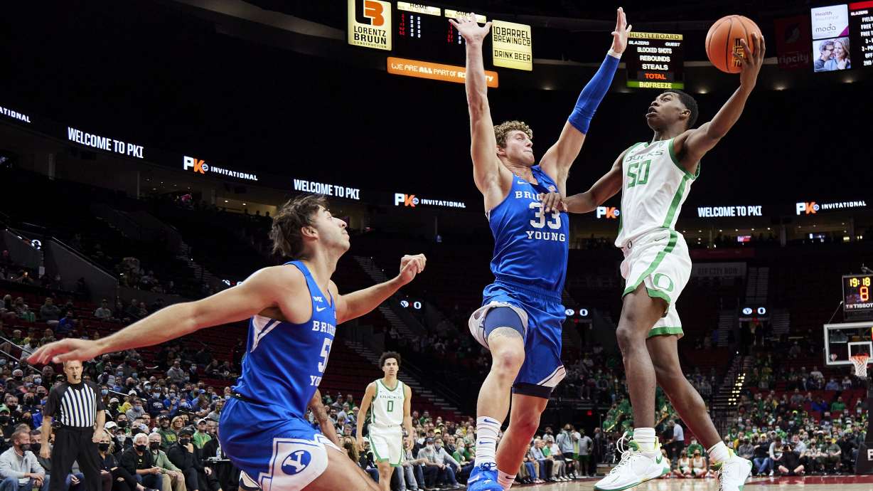 Oregon forward Eric Williams Jr., right, shoots over BYU forward Caleb Lohner, during the first half of an NCAA college basketball game in Portland, Ore., Tuesday, Nov. 16, 2021.