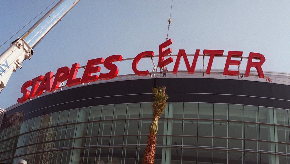 Construction workers put the finishing touches on the Staples Center sign outside the arena in downtown Los Angeles on Sept. 16, 1999. Staples Center is getting a new name. Starting Christmas Day, it will be Crypto.com Arena. The downtown Los Angeles home of the NBA's Lakers and Clippers, the NHL's Kings and the WNBA's Sparks will change its name after 22 years of operation, arena owner AEG announced Tuesday.
