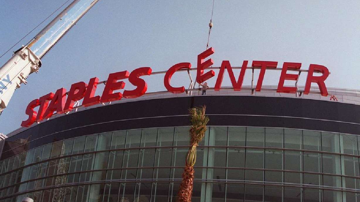Construction workers put the finishing touches on the Staples Center sign outside the arena in downtown Los Angeles on Sept. 16, 1999. Staples Center is getting a new name. Starting Christmas Day, it will be Crypto.com Arena. The downtown Los Angeles home of the NBA's Lakers and Clippers, the NHL's Kings and the WNBA's Sparks will change its name after 22 years of operation, arena owner AEG announced Tuesday.