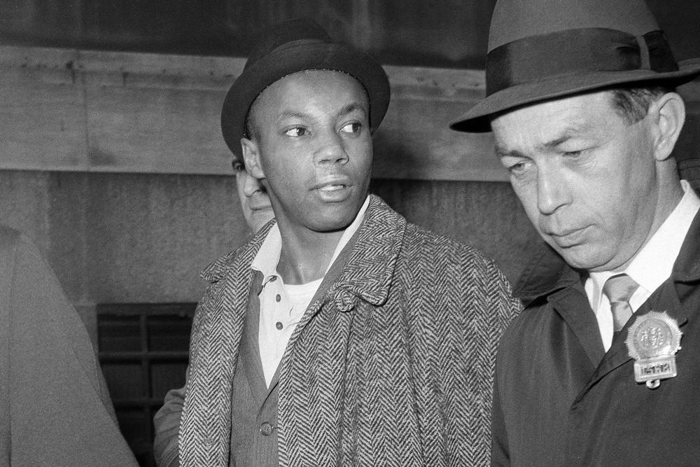 Norman 3X Butler, 26, a suspect in the slaying of Malcolm X, is escorted by detectives at police headquarters, after his arrest, in New York, on Feb. 26, 1965. Butler, one of two men convicted in the assassination of Malcolm X, is set to be cleared after more than half a century, with prosecutors now saying authorities withheld evidence in the civil rights leader's killing, according to a news report Wednesday.
