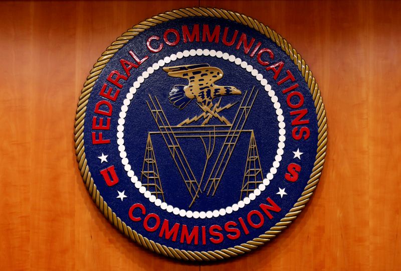 The Federal Communications Commission logo is seen before the FCC Net Neutrality hearing in Washington Feb. 26, 2015. The FCC voted unanimously on Thursday to require wireless carriers to allow texting to the new "988" U.S. National Suicide Prevention hotline that will begin by July 2022.