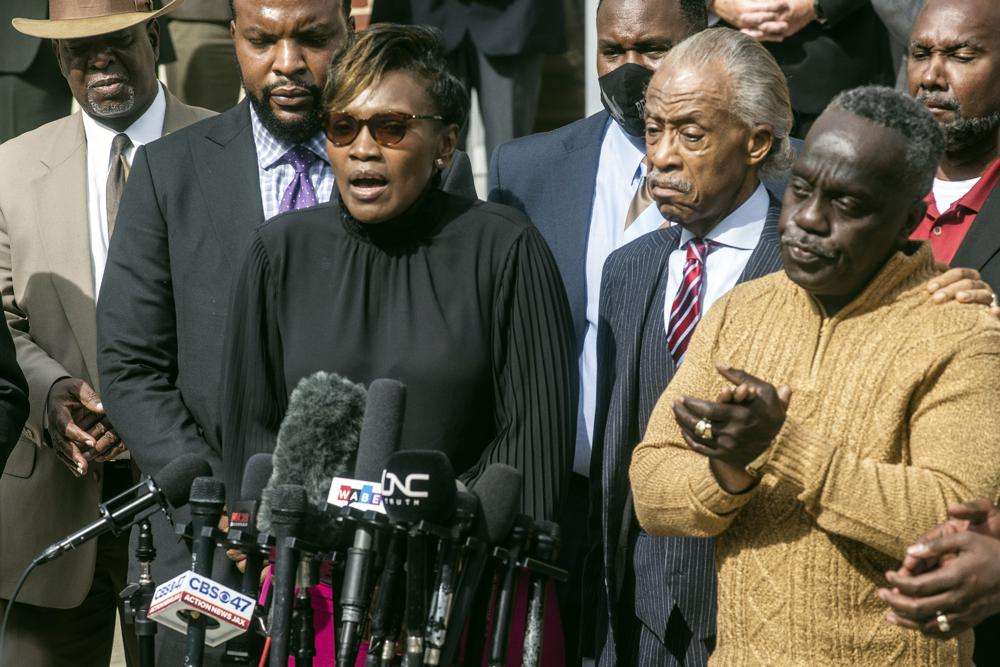 Marcus Arbery, right, applauds as his former wife Wanda Cooper speaks about the slaying of their son Ahmaud Arbery as Civil rights leader Rev. Al Sharpton stands between them outside the Glynn County courthouse, Nov. 10, in Brunswick, Ga. Rev. Sharpton led a prayer and spoke out against injustice during the noon break in the trial of three men charged with murder in Ahmaud Arbery's shooting death.