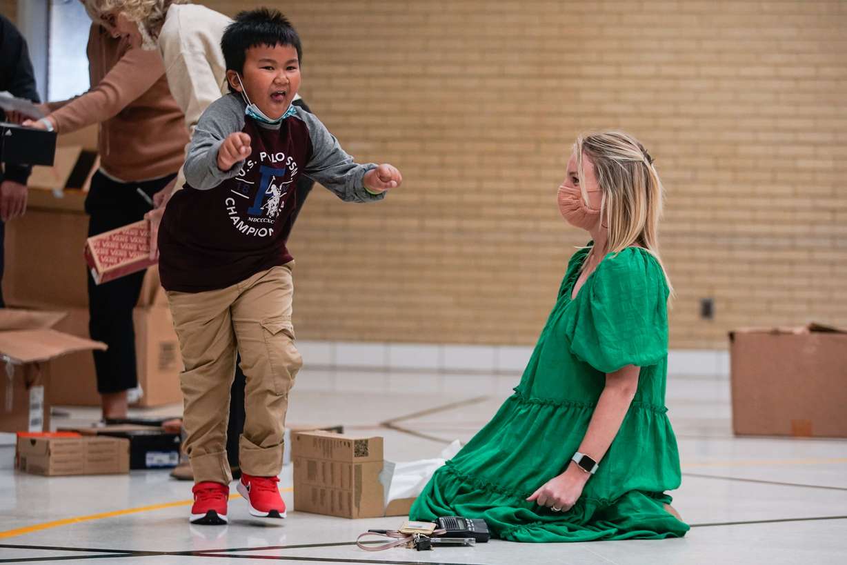 Pioneer Elementary School assistant principal Lindsey Weaver watches a student dance after getting his new pair of shoes from Altius Mortgage Group on Thursday, in West Valley City.