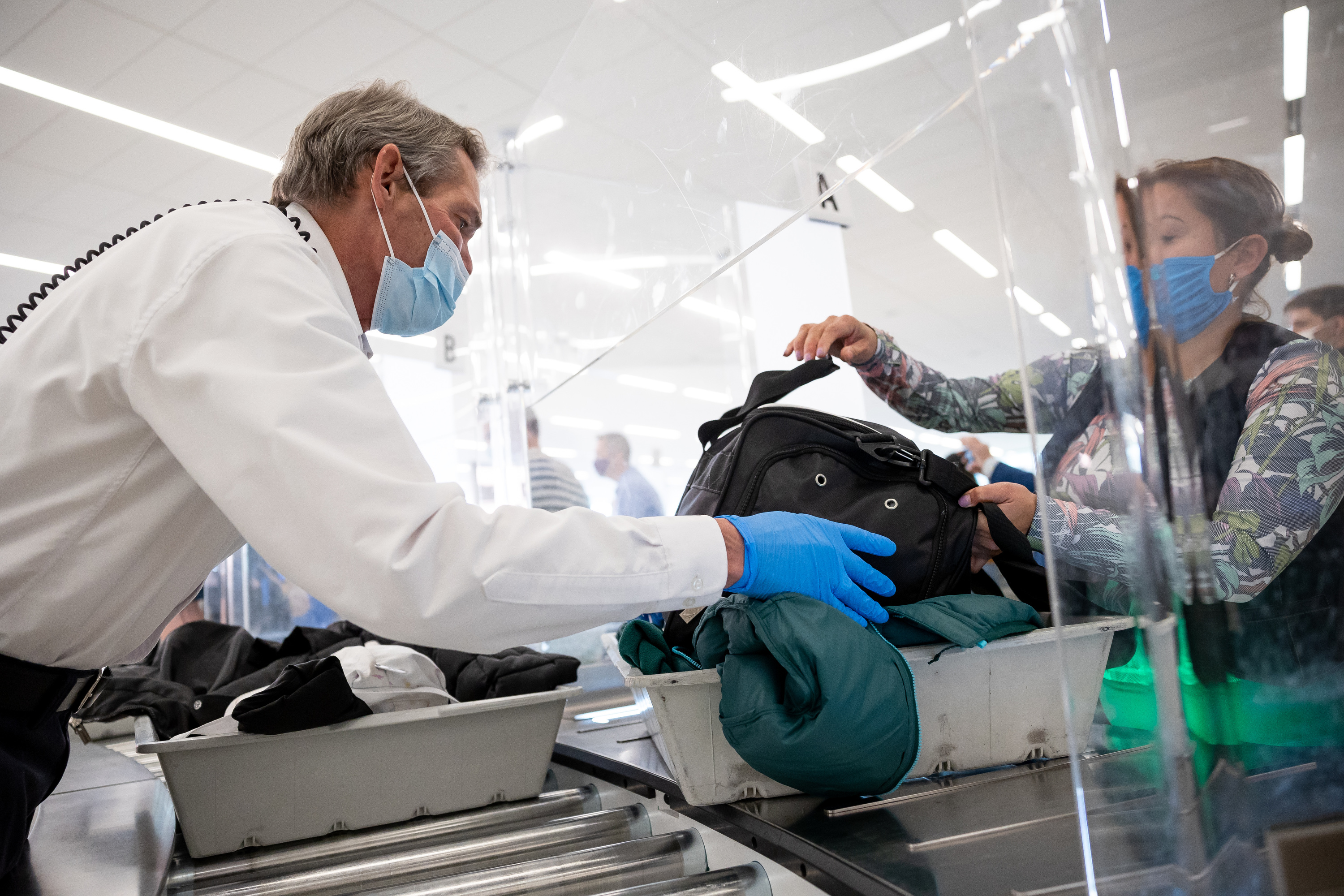 Matthew Yeates, a Transportation Security Administration officer, helps travelers at the security checkpoint at Salt Lake City International Airport in Salt Lake City on Thursday.