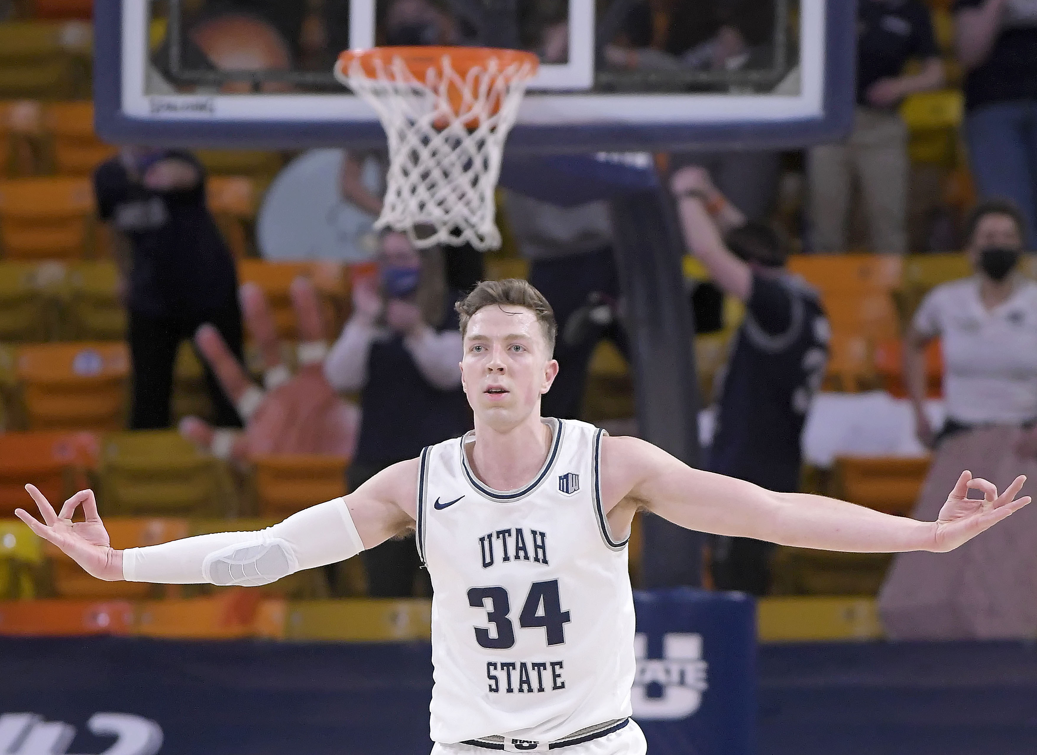 Utah State forward Justin Bean (34) celebrates after making a three-point basket during the second half of an NCAA college basketball game against Nevada, Friday, Feb. 26, 2021, in Logan, Utah.