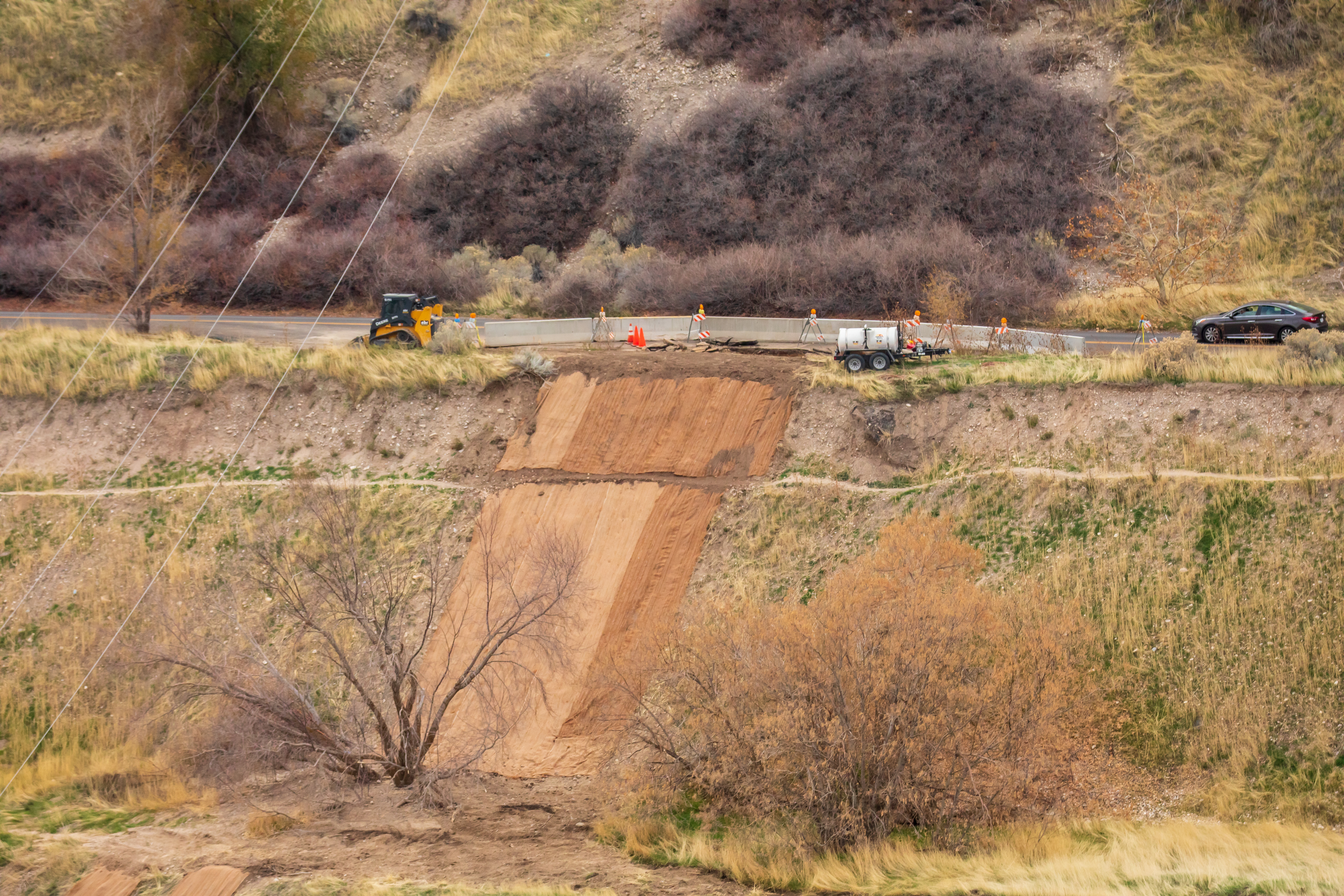 A car travels past construction on Bonneville Boulevard Friday. The section was washed out by storms last month.