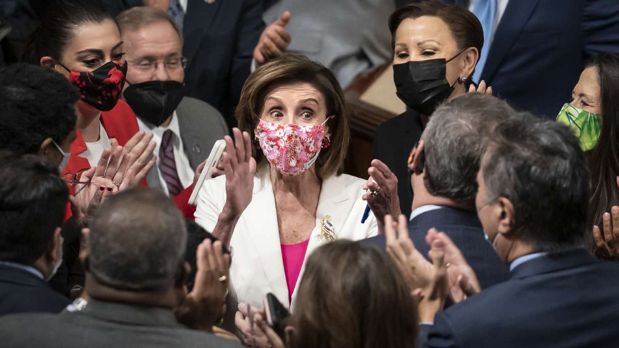 Speaker of the House Nancy Pelosi, D-Calif., celebrates in the chamber with her caucus after the House approved the Democrats' sweeping social and environment bill, giving a victory to President Joe Biden, in Washington on Friday.