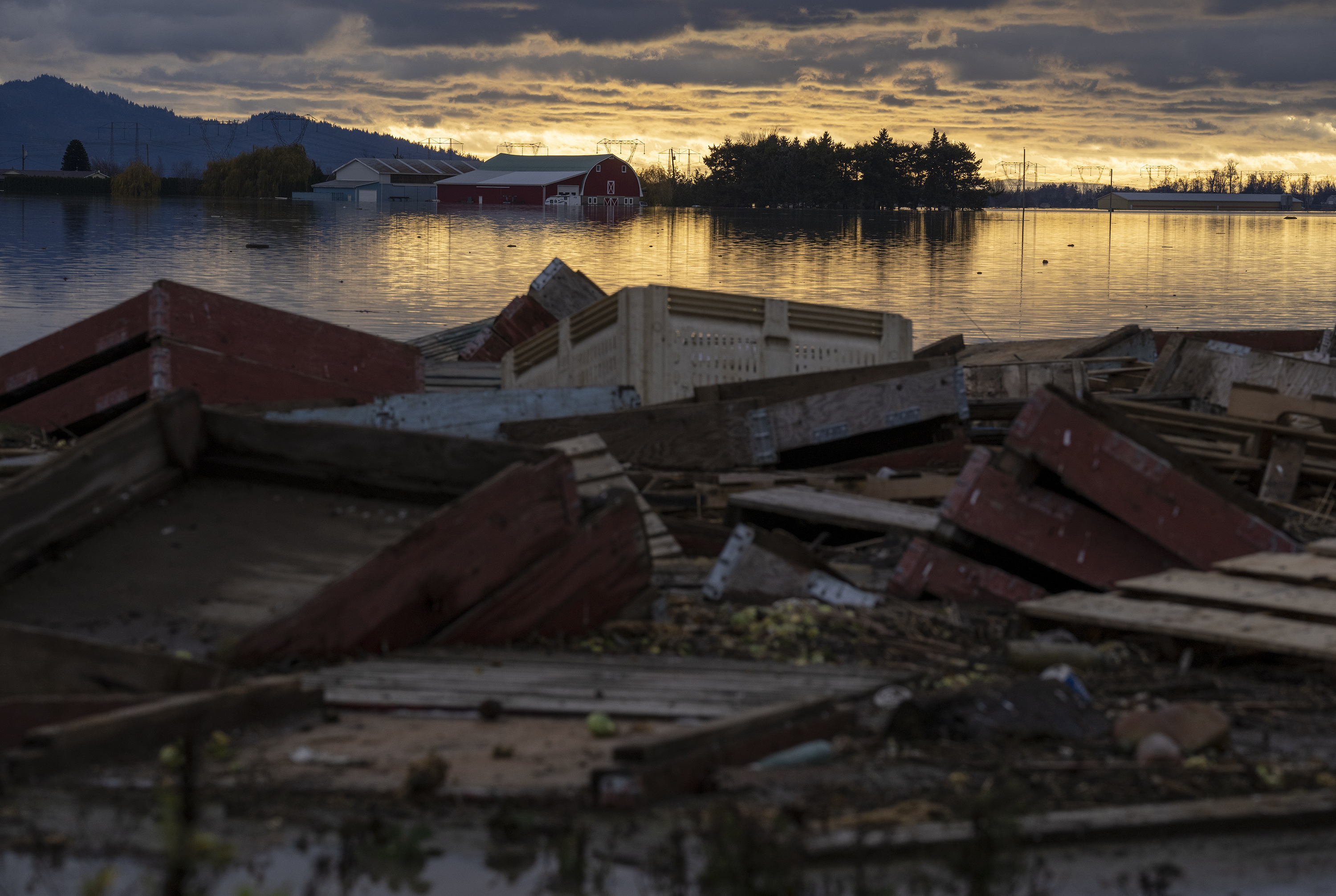 Debris is piled up as farms are surrounded by floodwaters caused by heavy rains and mudslides in Abbotsford, British Columbia on Friday. 