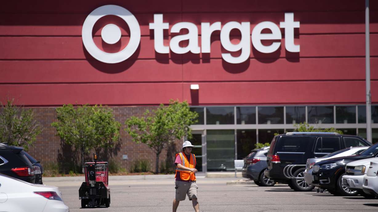 A worker collects shopping carts in the parking lot of a Target store on June 9, in Highlands Ranch, Colo. Target will no longer open its stores on Thanksgiving Day, the company announced Monday.