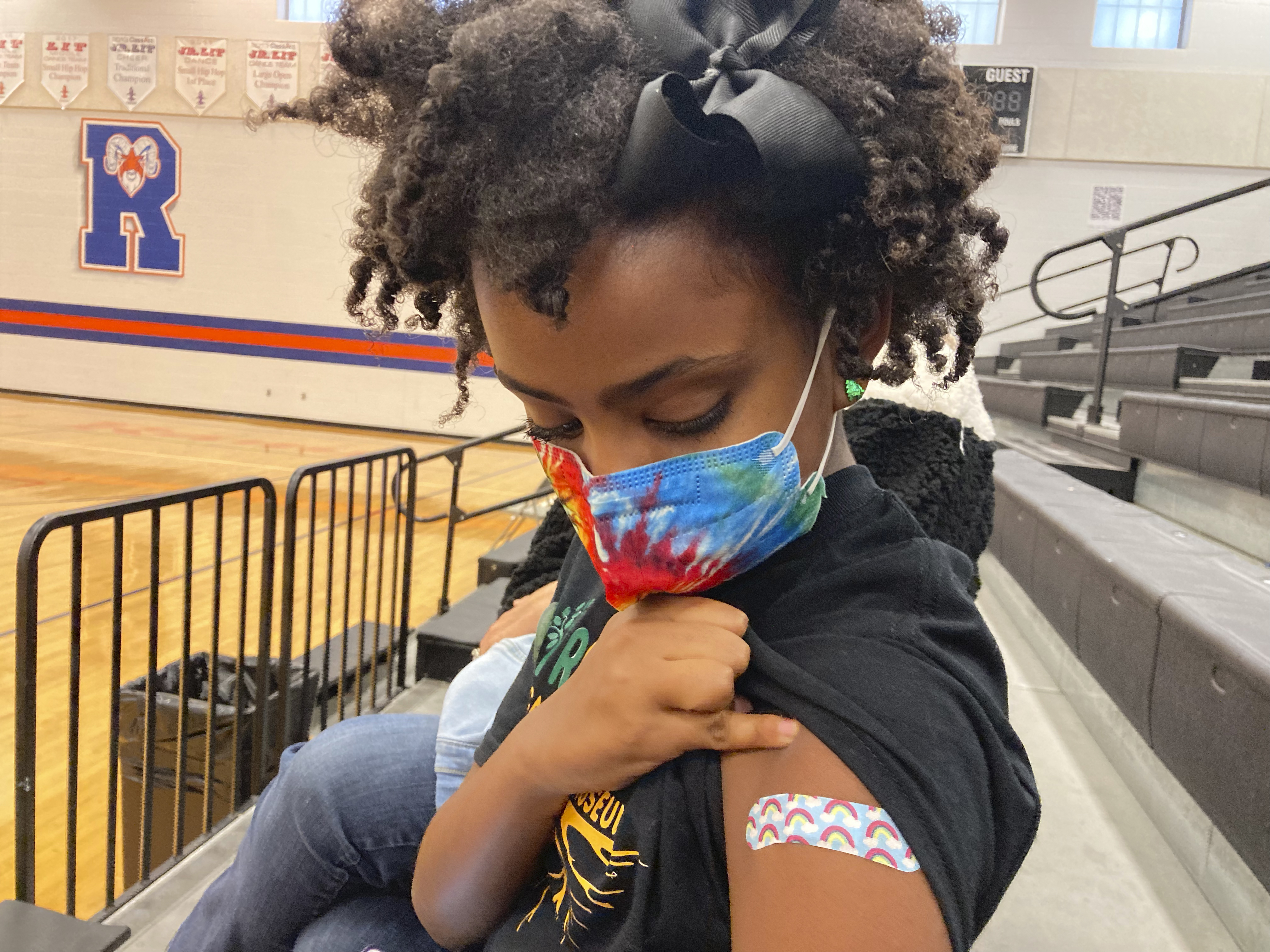 Solome Walker, 9, looks down at her bandage after getting her first Pfizer COVID-19 shot at a vaccination clinic for young students at Ramsey Middle School on Nov. 13 in Louisville, Ky.