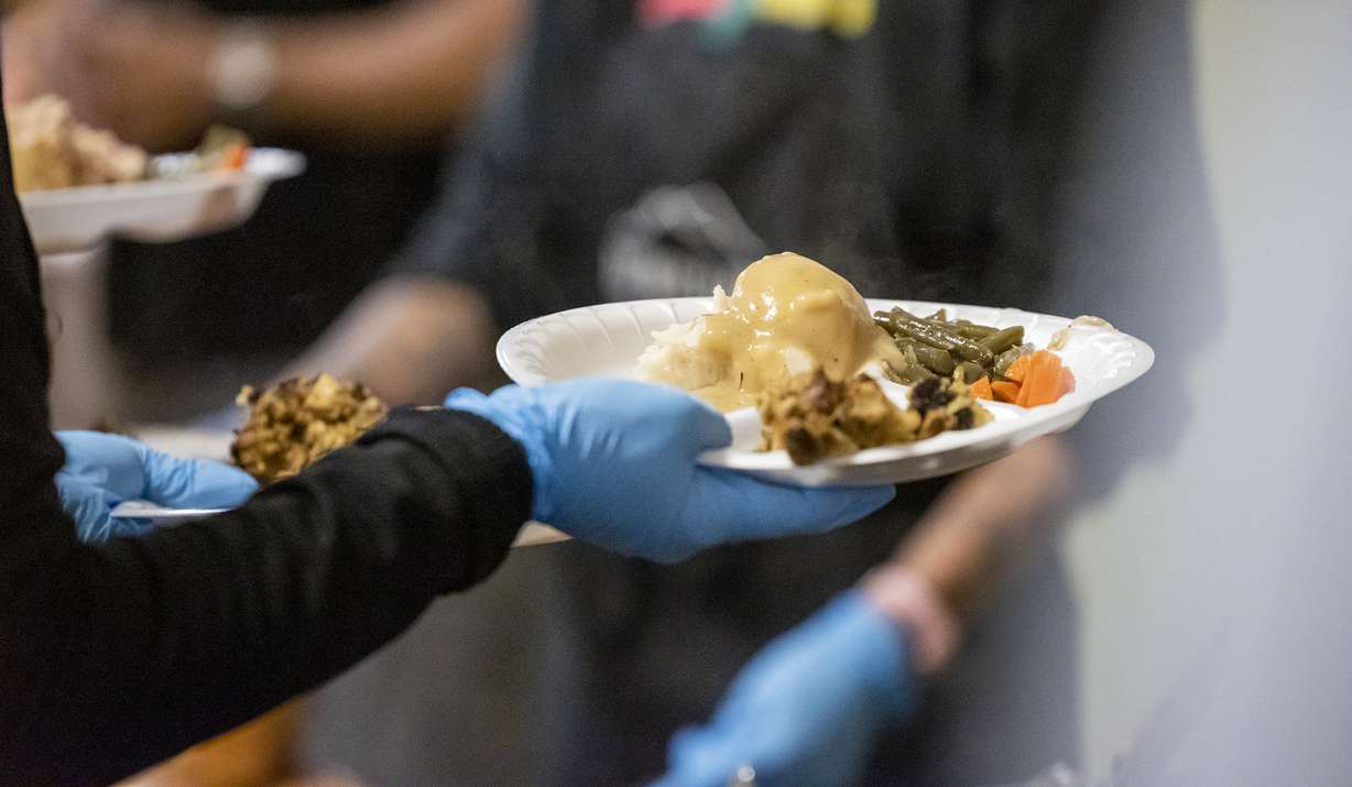 Utah Gov. Spencer Cox and Lt. Gov. Deidre Henderson serve a Thanksgiving dinner at the Rescue Mission of Salt Lake in Salt Lake City on Monday.