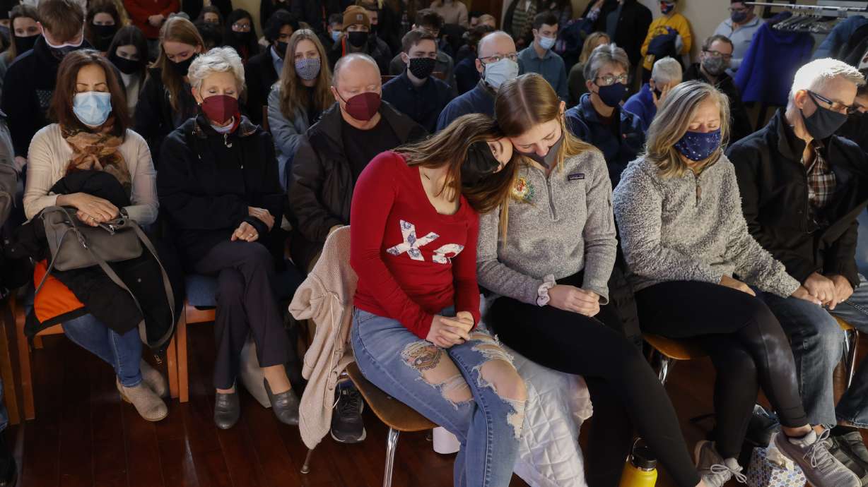 A woman leans on a friend during a prayer vigil at Carroll University in Waukesha, Wis., on Monday after an SUV plowed into a Sunday Christmas parade, killing several and injuring dozens of others.