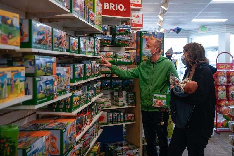 Code Neider, left, and his wife, Tristan, carrying
their newborn son, Rhett, shop for toys at Tutoring Toy in Salt
Lake City on Monday.