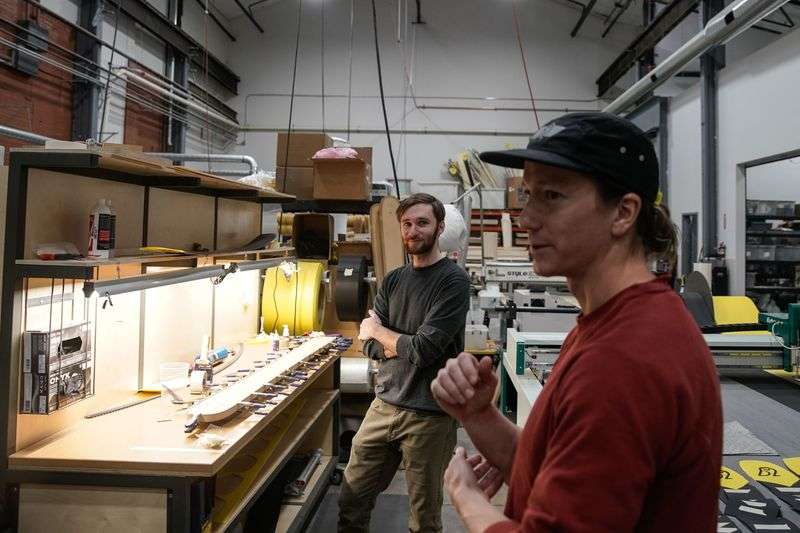 Xan Marshland, manager of brand development, back,
watches Pep Fujas, professional skier and vice president of
marketing and product development, during tour of WNDR Alpine, a
local ski company that uses algae-based bioplastics to replace
plastics used in ski construction, in Salt Lake City on Friday.