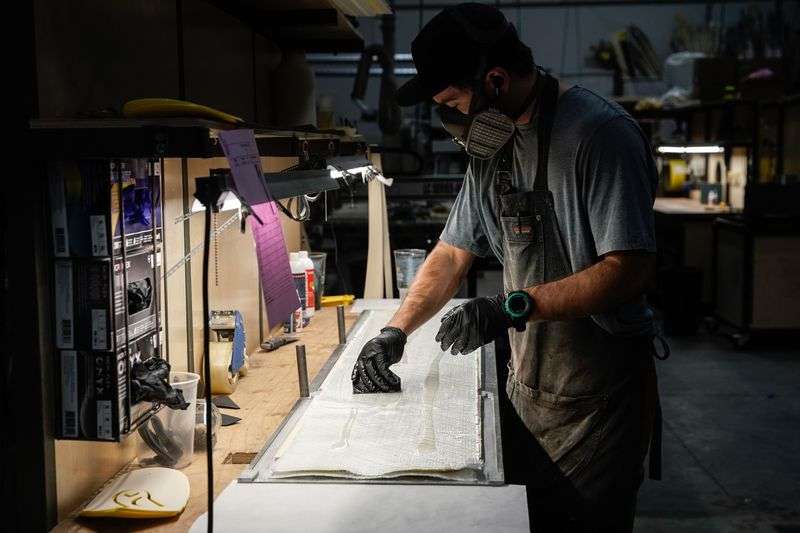 Dane Weister, product specialist at WNDR Alpine, a
local company that uses algae-based bioplastics to replace plastics
used in ski construction, glues the layers of a ski together at the
company’s facility in Salt Lake City on Friday.
