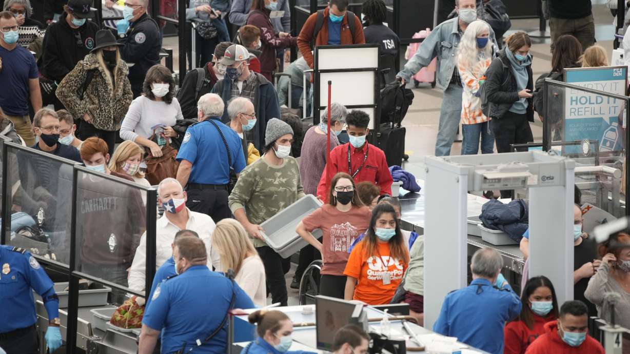 Travelers queue up at the south security checkpoint as traffic increased with the approach of the Thanksgiving Day holiday Tuesday, at Denver International Airport in Denver.