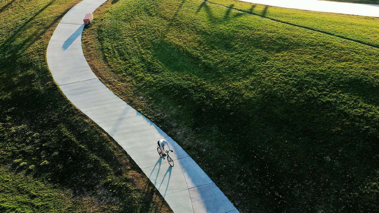A biker rides through Sugar House Park in Salt Lake City on Tuesday. The weather is expected to be dry and clear for holiday travel in Utah.