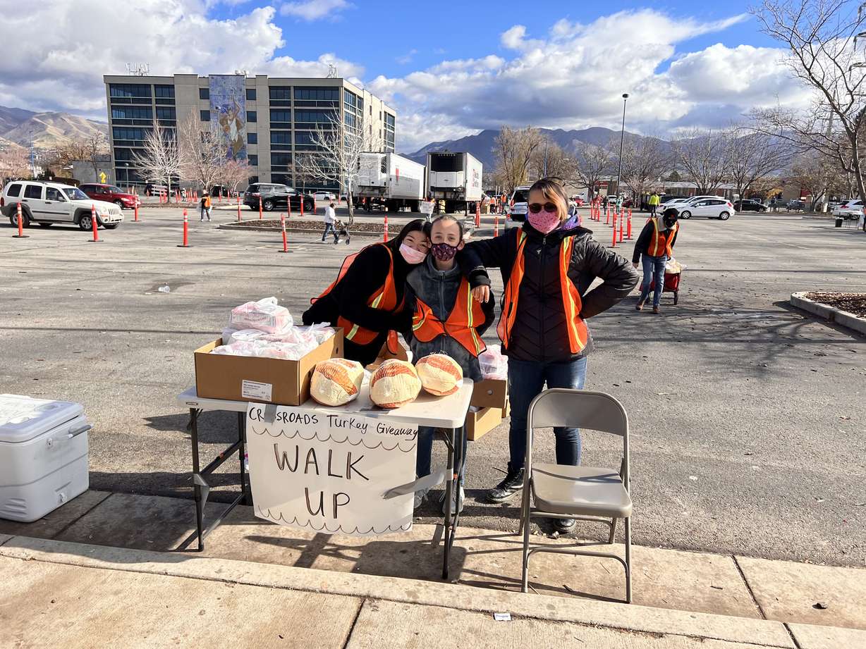 Lauryn Vardeny, Nora Vardeny and Saerichai Baker-Rajsavong pose for a picture while volunteering at Crossroad Urban Center's Thanksgiving Turkey Giveaway at the Smith's Ballpark parking lot in Salt Lake City on Wednesday.